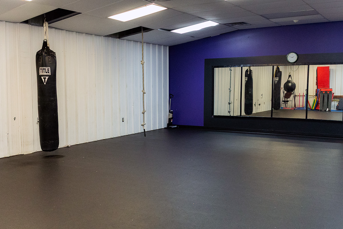 decfdb1f76a83e7c3bba7d6040e5b2dd Children playing basketball in a gym, with two players in red jerseys jumping to reach the ball and two others in purple jerseys actively participating. The YMCA logo is visible in the background, highlighting the community sports environment.